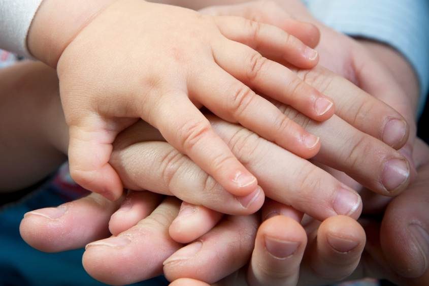 A close up of a group of hands holding each other, symbolizing the unity and trust within a full service law firm.