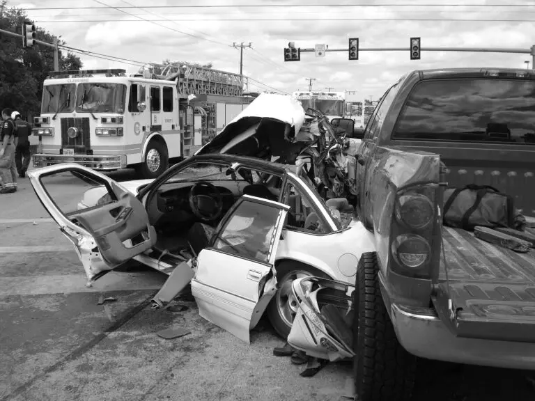 A black and white photo of a car that has been hit by a fire truck, requiring the expertise of a Personal Injury Attorney.