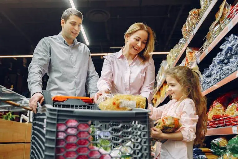 A joyful family of three shopping together in a supermarket, creating a memorable experience.